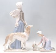 Lladro - A large porcelain figure of a 1920's lady wearing a bonnet and scarf walking her long