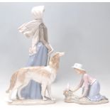 Lladro - A large porcelain figure of a 1920's lady wearing a bonnet and scarf walking her long