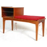A retro mid century teak wood telephone table bench. Raised on tapering legs with a moquette