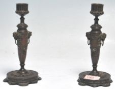 A pair of 19th Century cast bronze Grand Tour candlesticks having reeded cylindrical scones on