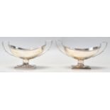 A pair of silver hallmarked salt cellars having twin square handles raised on square plinth bases (