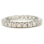 A white gold and diamond eternity ring. The ring with inset 24 round cut diamonds, estimated diamond