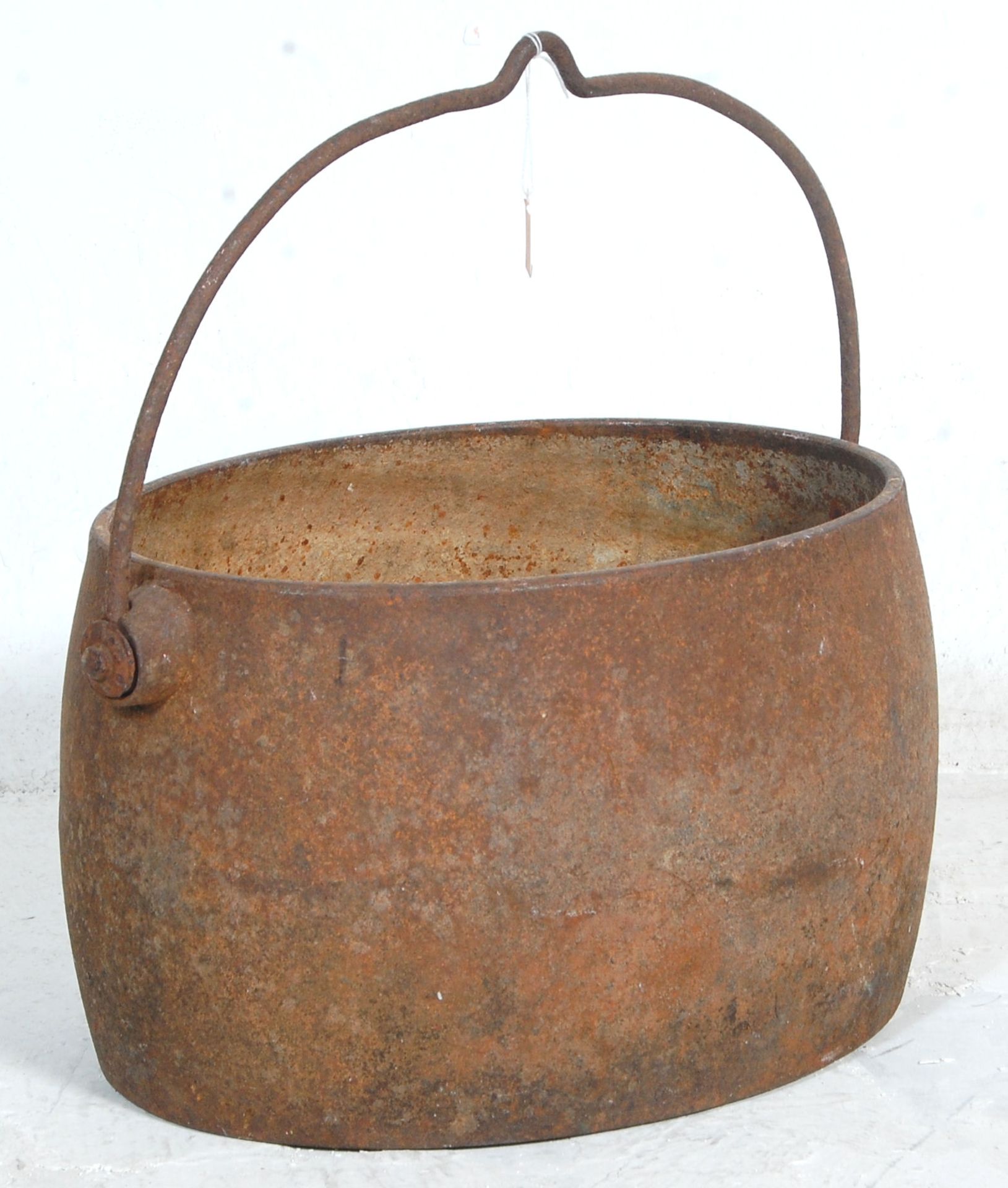 A late 19th Century Victorian iron cooking pot / cauldron having a large swing handle with hook