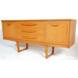 A mid century Danish inspired teak sideboard credenza being raised on tapering legs with a wide body