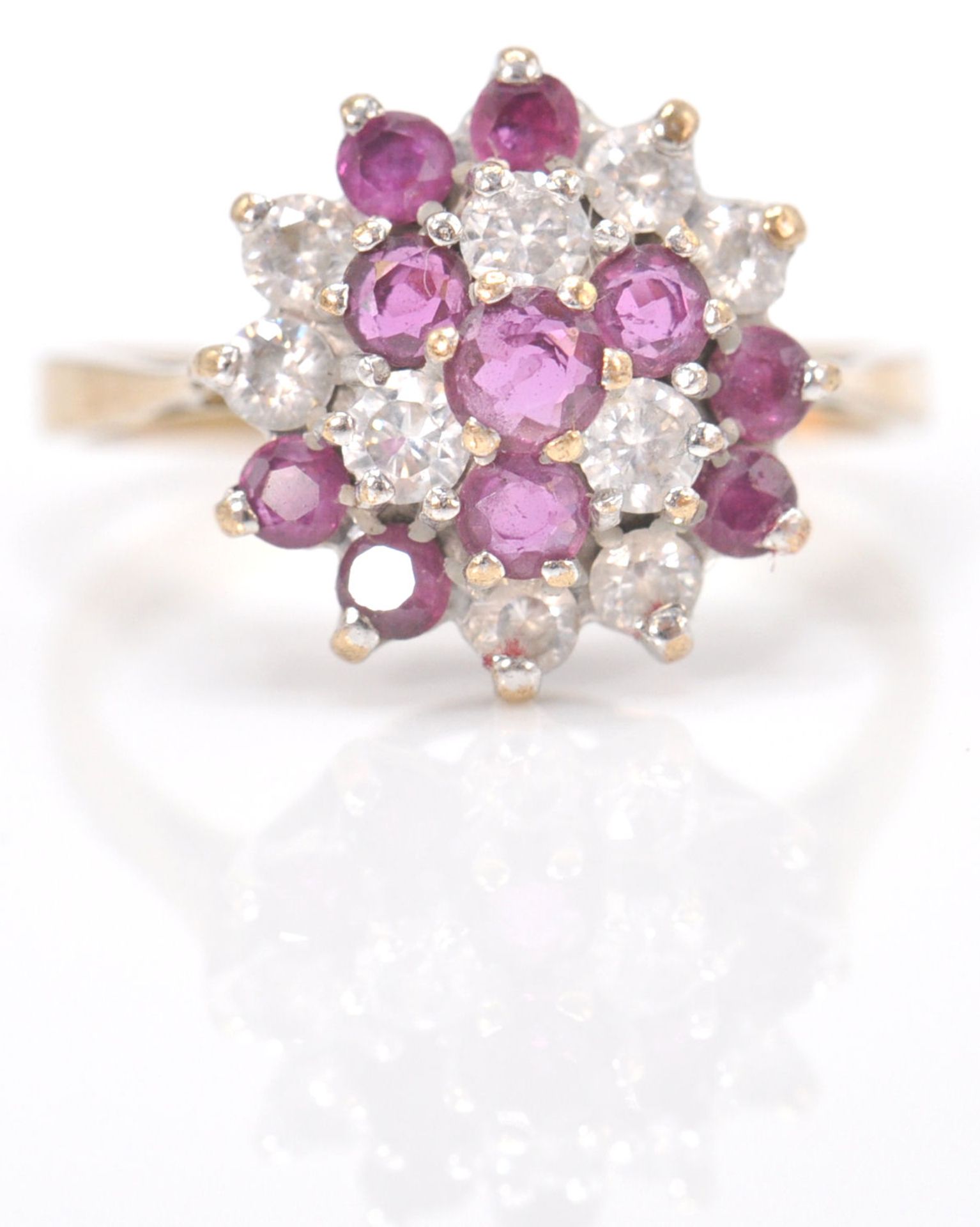 A 9ct gold hallmarked cluster ring. The ring set with amethyst and white mixed cut stones  in basket