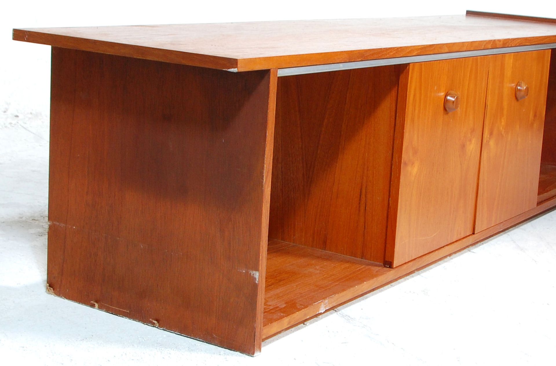 A low mid 20th Century retro teak wood unit / sideboard having sliding doors across open sections - Bild 2 aus 5