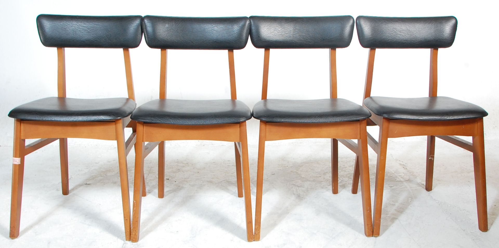 A good set of four retro mid 20th Century teak framed dining chairs raised on splayed legs united by