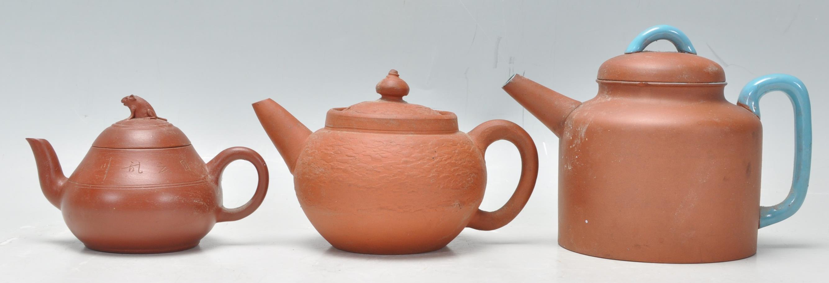A collection of Chinese yixing teapots each of red clay terracotta form. To include a cylindrical