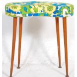 A retro vintage kidney shaped stool upholstered in blue yellow and white fabric raised on tapering