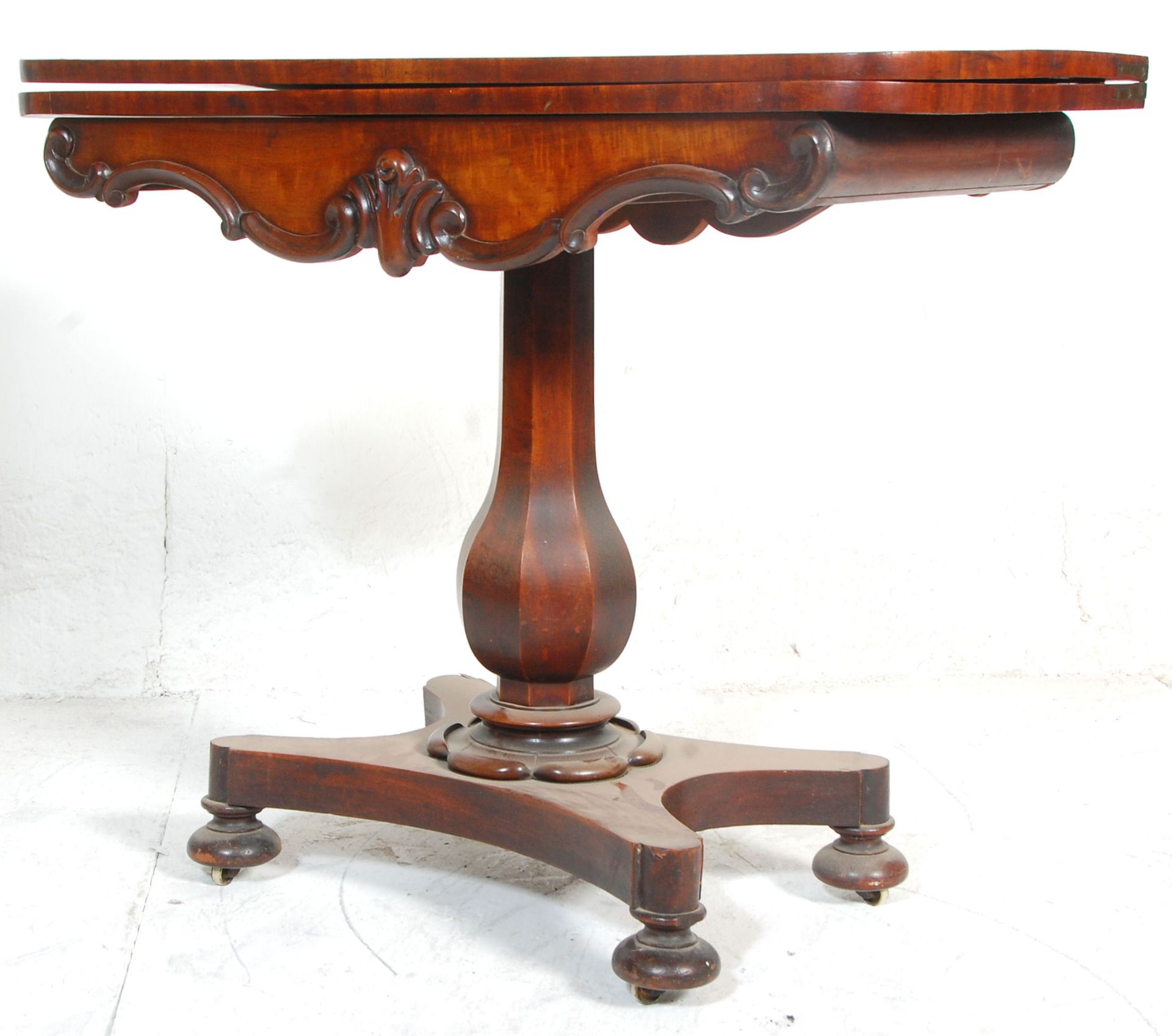 A 19th century Regency William IV mahogany card - games table. Raised on a quadruped base with bun