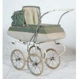 A vintage retro mid 20th Century Tri-ang made child's push along toy pram finished in pale green and