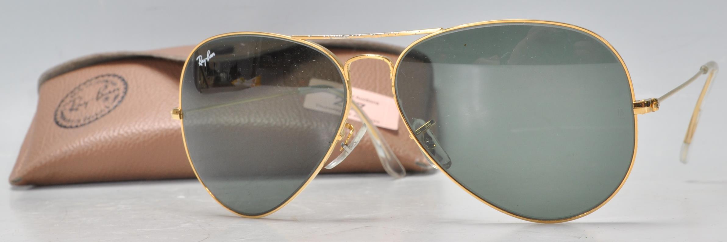 A pair of vintage gentlemen's Ray Ban aviator sunglasses having gilt wire frames and dark lenses,