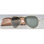 A pair of vintage gentlemen's Ray Ban aviator sunglasses having gilt wire frames and dark lenses,