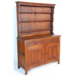A 1930's oak dresser having carved decoration in the linenfold pattern to the panelled doors with