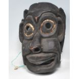 A Himalayan / Nepalese folk art carved wooden shaman's mask in the form of a stylised ebonised human