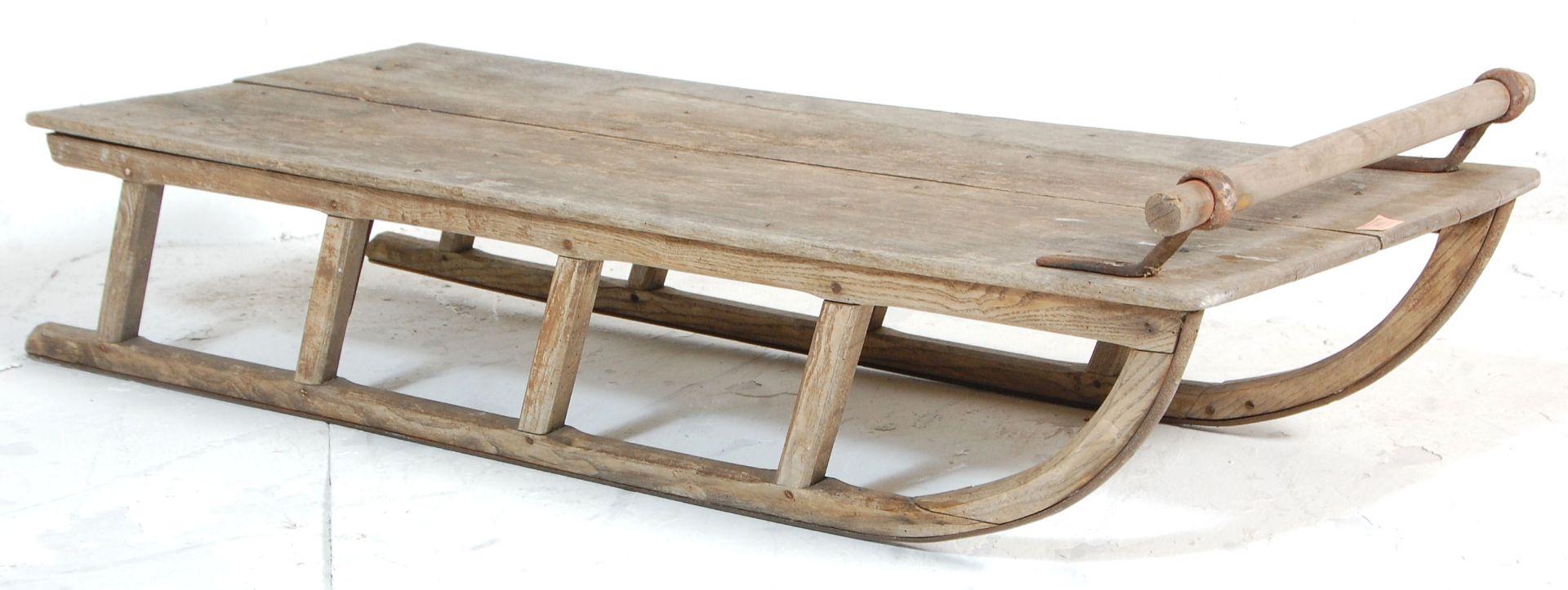 A vintage 20th Century scrubbed wooden sledge / sled / sleigh having a turned handle to the top