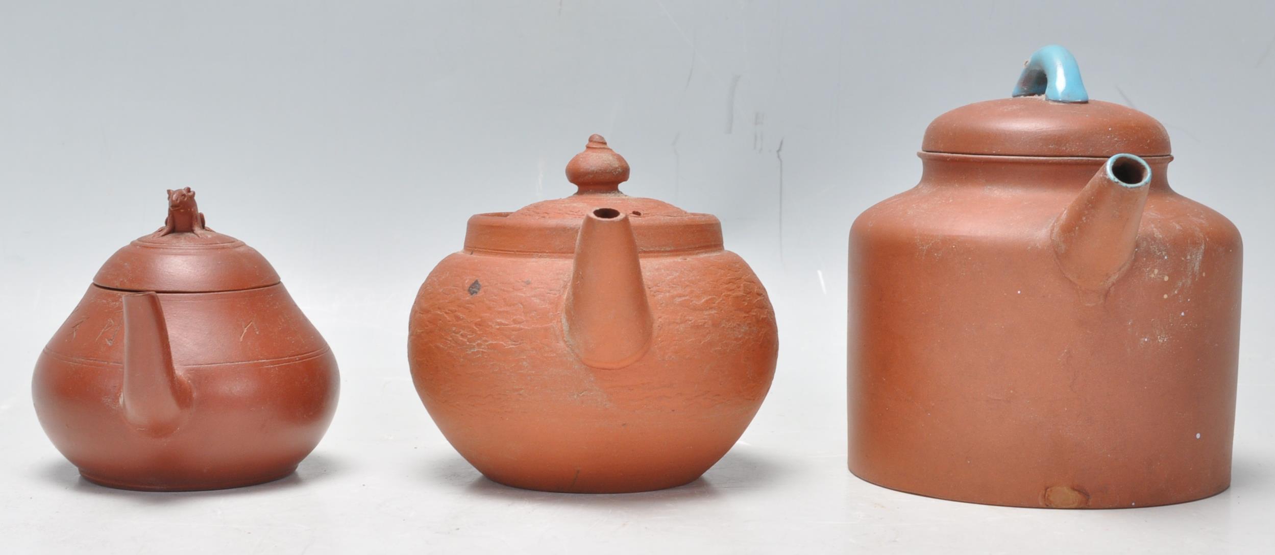 A collection of Chinese yixing teapots each of red clay terracotta form. To include a cylindrical - Image 2 of 12