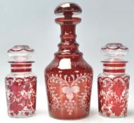 A group of early 20th Century antique bohemian ruby glass to include a bottle decanter having a