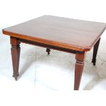 An Edwardian mahogany wind out dining table. The table being raised on tapering legs with castors