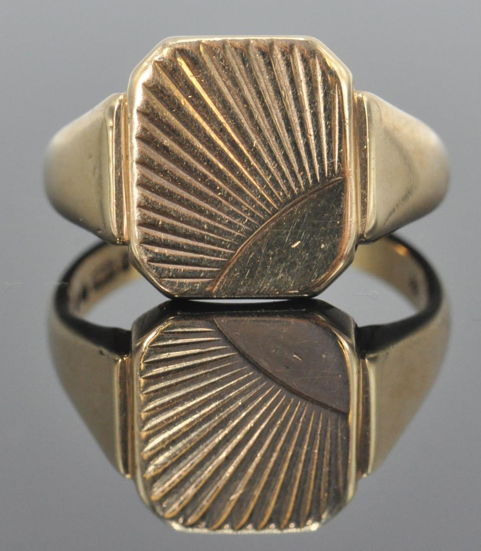 A hallmarked 9ct gold gentleman's signet ring having sunrise / sunburst decorated cartouche.