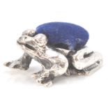 A stamped sterling silver pincushion in the form of an Amazonian treefrog with a blue velvet cushion