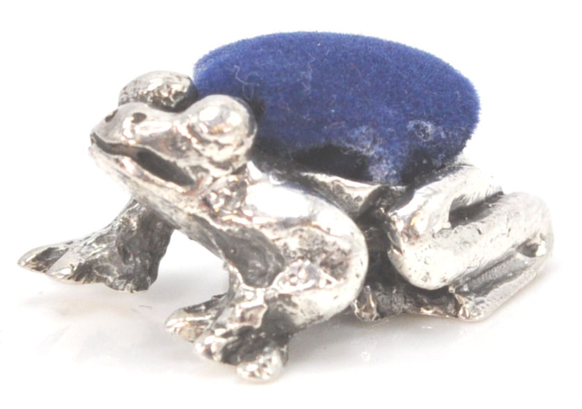 A stamped sterling silver pincushion in the form of an Amazonian treefrog with a blue velvet cushion