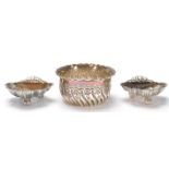 A pair of silver hallmarked Edwardian salt cellars in the form of scallop shells raised on three