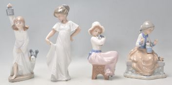 A group of four Valenican Nao porcelain figurines to include a girl wearing a white dress, a