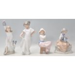 A group of four Valenican Nao porcelain figurines to include a girl wearing a white dress, a