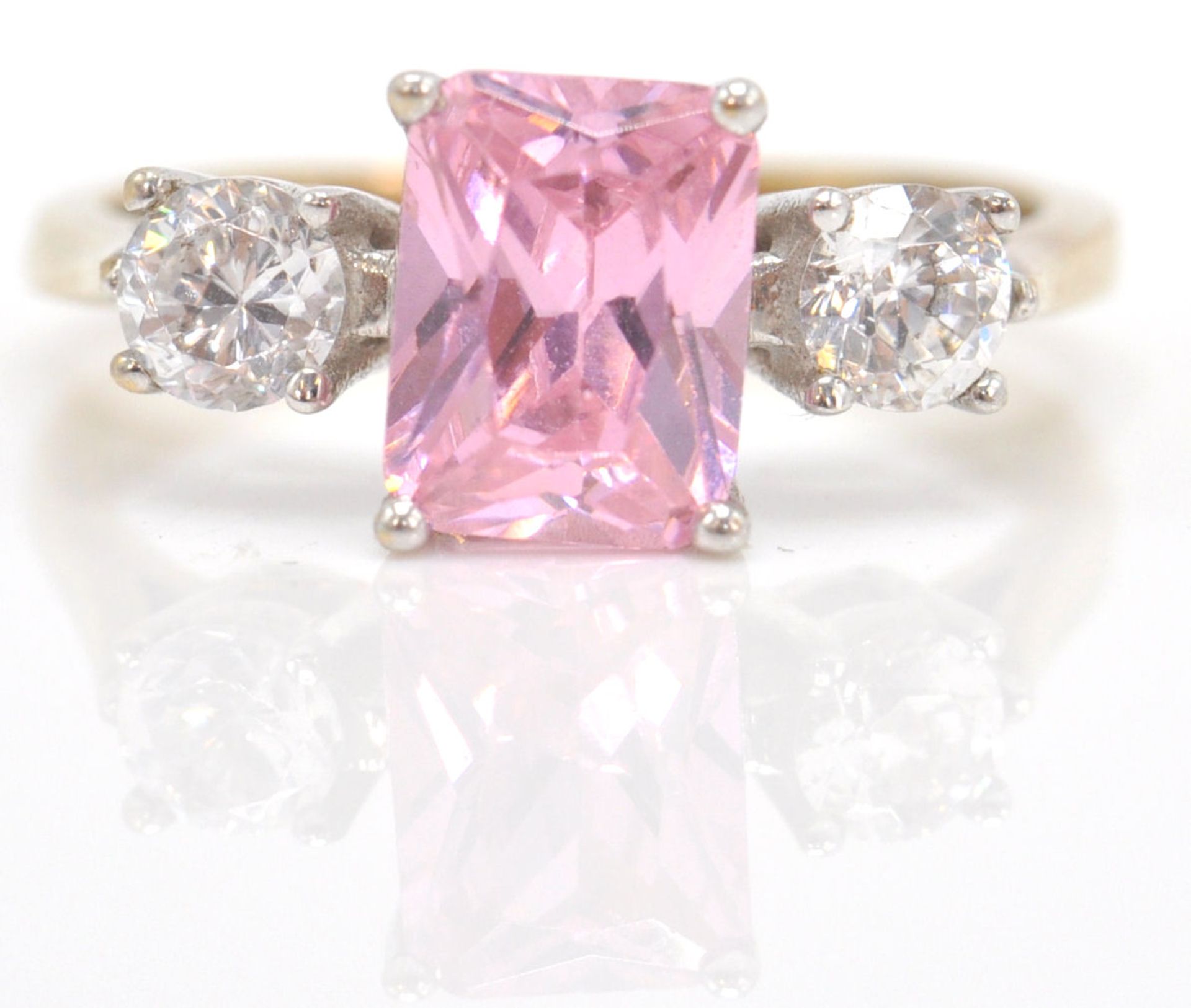 A 9ct gold hallmarked 3 stone ring. The ring with central pink CZ in prong setting flanked by cz