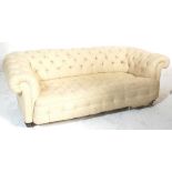 A Victorian 19th century large Chesterfield sofa settee. Raised on mahogany ring turned legs with