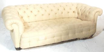 A Victorian 19th century large Chesterfield sofa settee. Raised on mahogany ring turned legs with