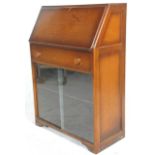 A vintage retro 20th Century fall front bureau bookcase having a sloping fall front desk opening