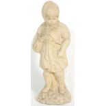 A composite stone garden figure / statue depicting a young girl wearing a hood stood upon a cobble