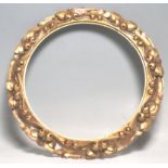 A 20th Century antique style wall hanging gilt frame having moulded scrolled decoration with foliate