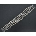A 14ct white gold 585 4 strand baroque pearl bracelet by JKA . The bracelet united by a 14ct gold