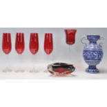 A matching group of four retro champagne flutes having red glass bowls and clear stems. Together