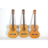 A group of three six string acoustic guitars. All guitars being Encore makes model ENC 36N having