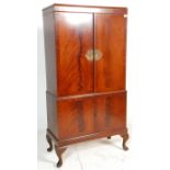 An early 20th Century Queen Anne style flame mahogany drinks / cocktail cabinet of two tiered