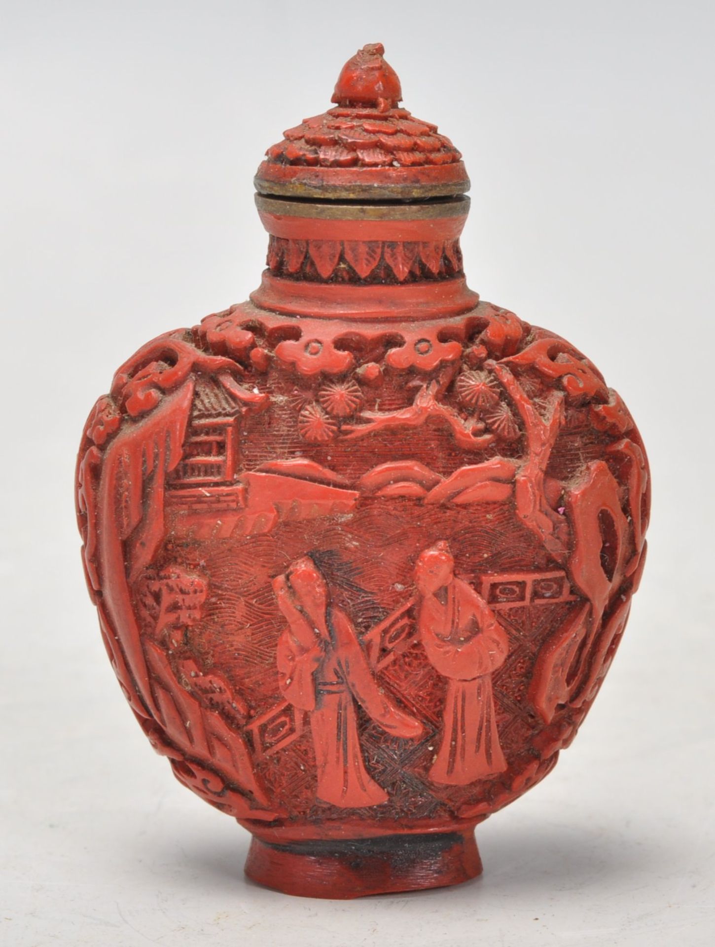 An Antique Chinese red cinnabar snuff bottle carved with landscape scenes and carved stopper atop. - Image 3 of 6