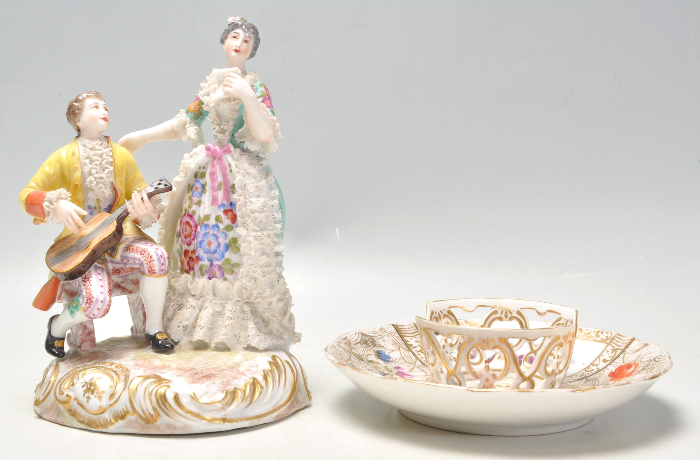 A 20th Century German Meissen / Dresden group figurine in the form of a couple with a seated man