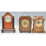 A collection of antique mantel clocks to include a faux birds eye maple German mantel clock with a