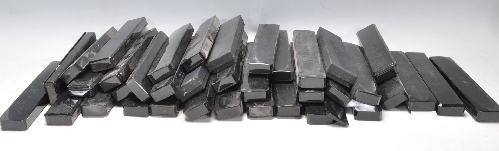 A collection of 35 black plastic necklace cases of rectangular form all containing cushioning