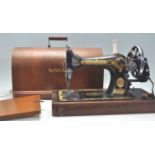A vintage early 20th Century oak cased Singer Sewing machine having a good dome carry case with
