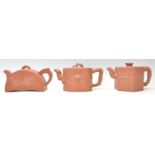 A collection of 3 20th Century Chinese Yixing red clay teapots of squat form having  short spouts