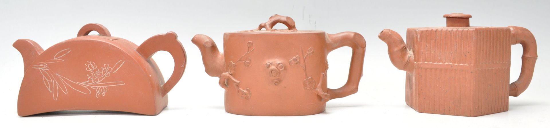 A collection of 3 20th Century Chinese Yixing red clay teapots of squat form having  short spouts