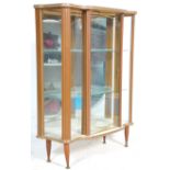 A retro mid 20th Century 1950's formica breakfront china display cabinet vitrine. Raised on tapering
