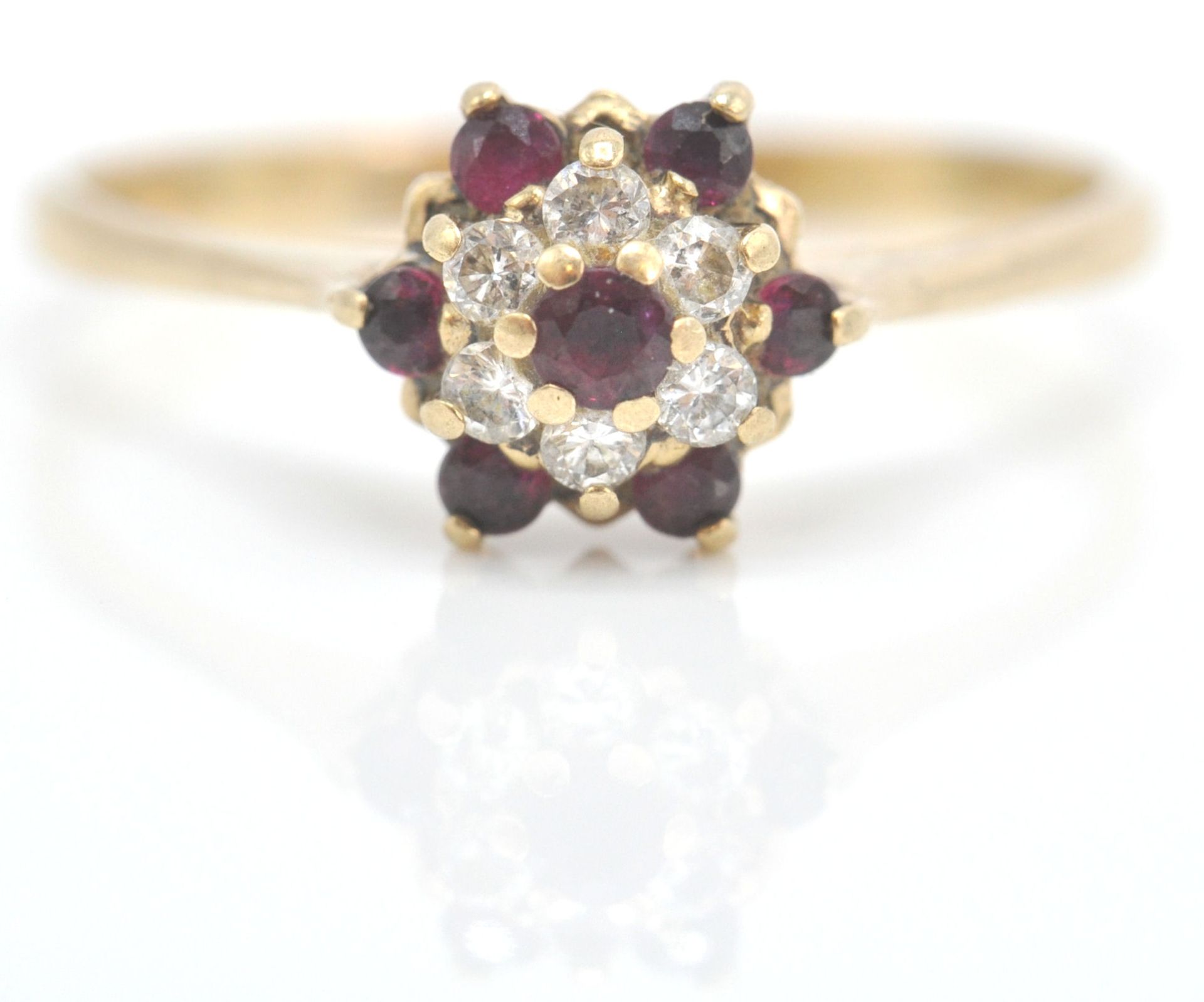 A 9ct gold ruby and diamond cluster ring. The ruby and diamond mixed cut stones in cluster setting