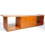 A low mid 20th Century retro teak wood unit / sideboard having sliding doors across open sections