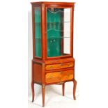 A 20th century French mahogany revival vitrine (display cabinet) of upright form being raised on